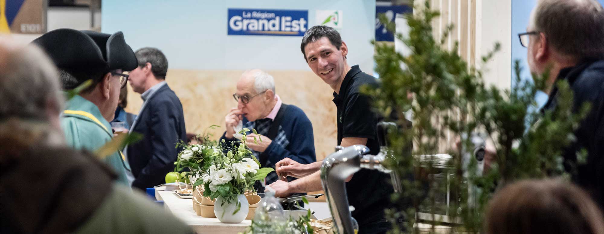 Smiling exhibitor behind his flower stall