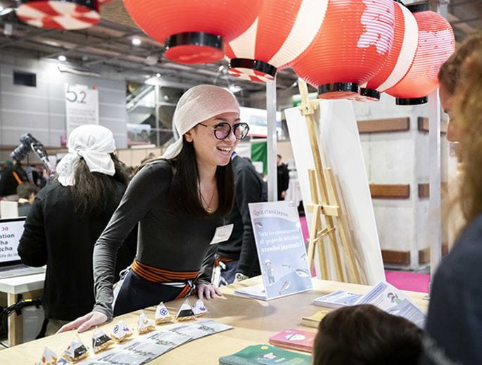 Female exhibitor smiling behind her stand