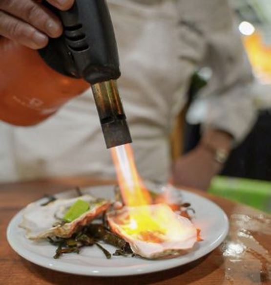 Chef flambéing an oyster